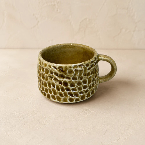 Handcrafted ceramic tea cup with olive green glaze and carved honeycomb texture