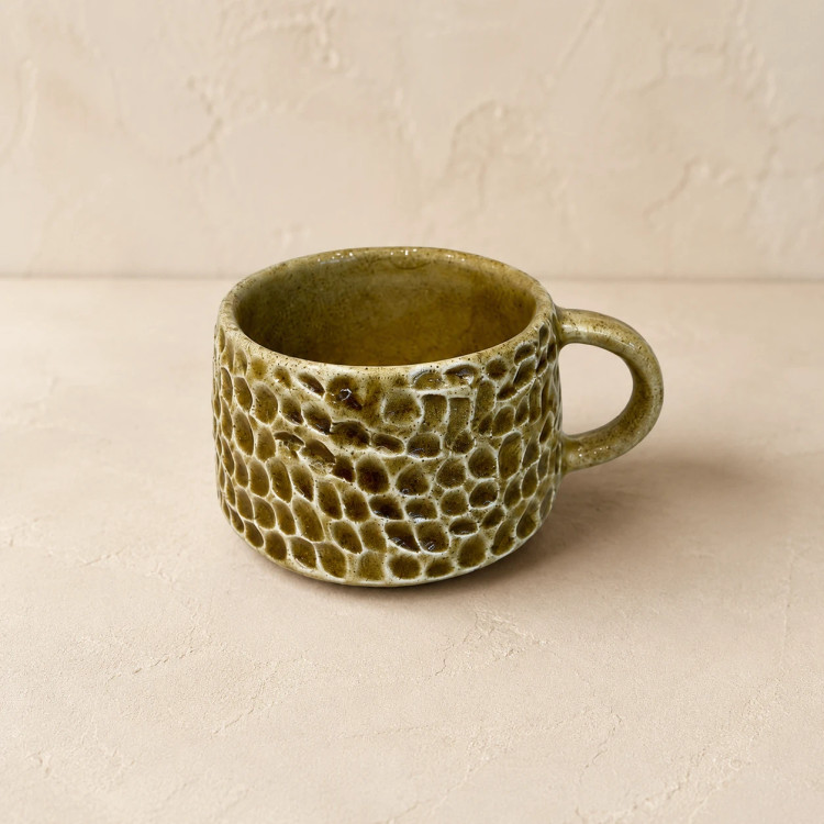 Handcrafted ceramic tea cup with olive green glaze and carved honeycomb texture